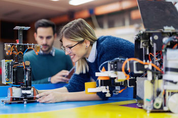 Eine Ingenieurswesen-Studentin arbeitet an einem technischen Gerät.